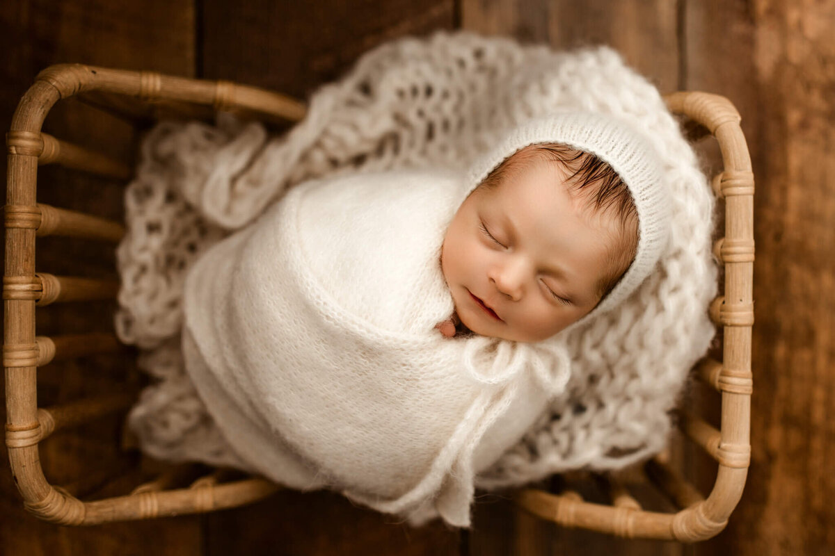 baby boy swaddled in infant prop bed by atlanta newborn photographer