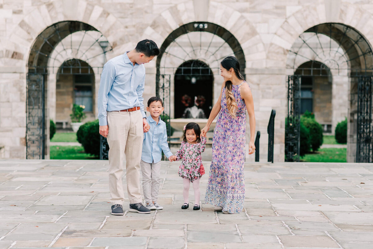 Children smiling and holding hands with their parents, captured by Denise Van, a Nothern Virginia family photographer