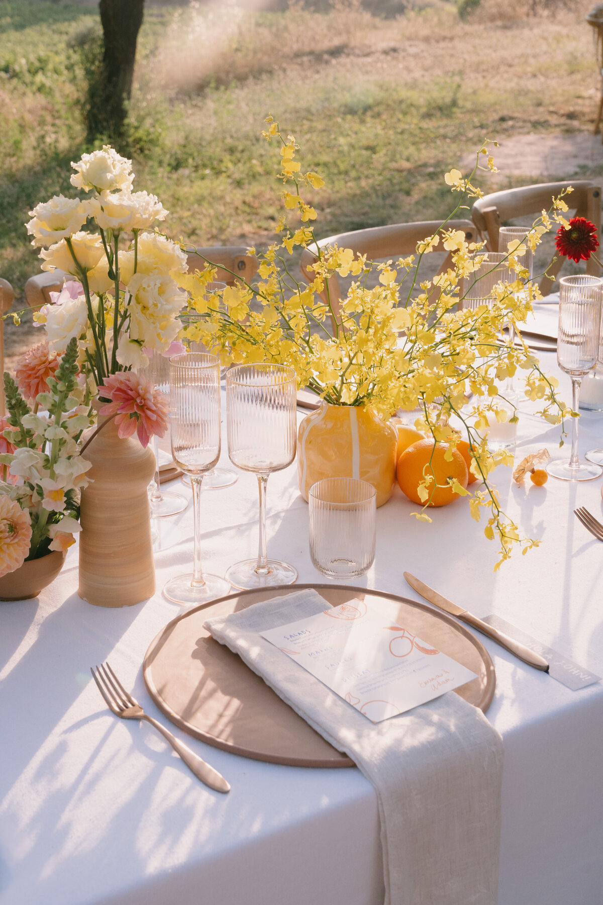 a photo take at wedding venue Masia Cabellut in Barcelona. The photos contains a close up of a wedding dinner table with yellow florals
