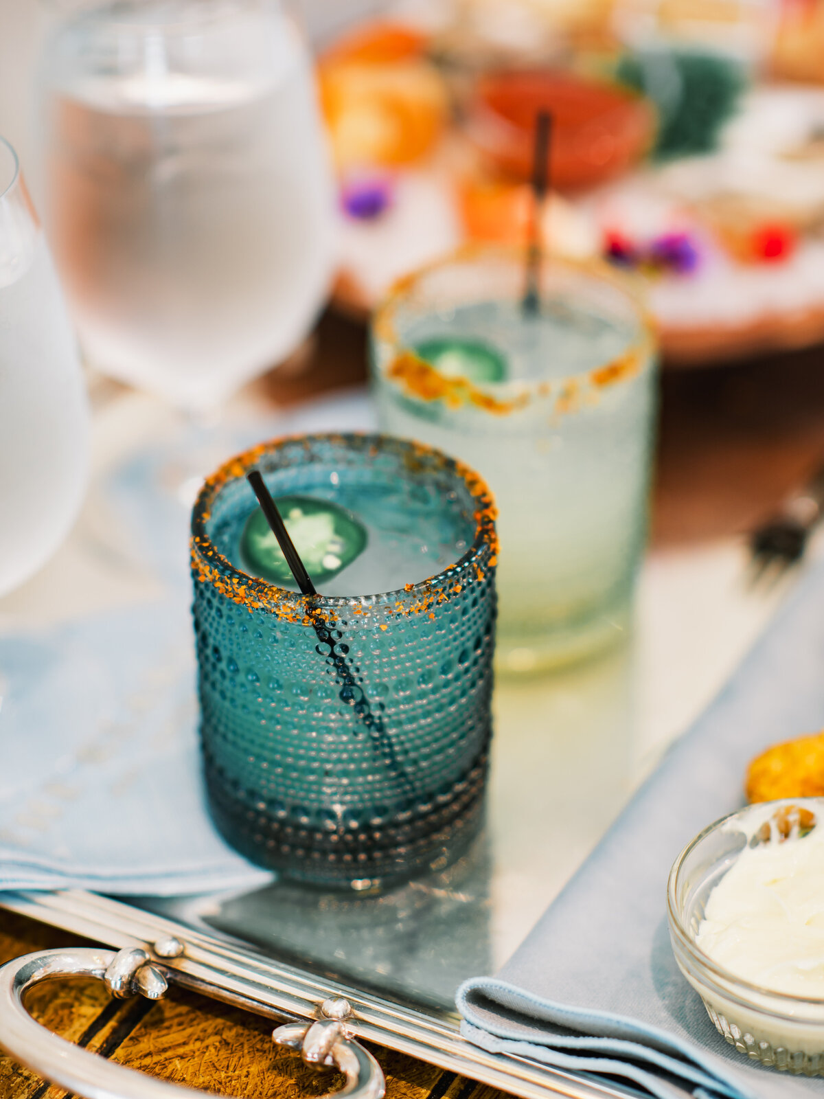 Close-up of signature craft cocktails in textured blue glassware on a silver tray at a wedding reception at Old Edwards Inn in Highlands, North Carolina.