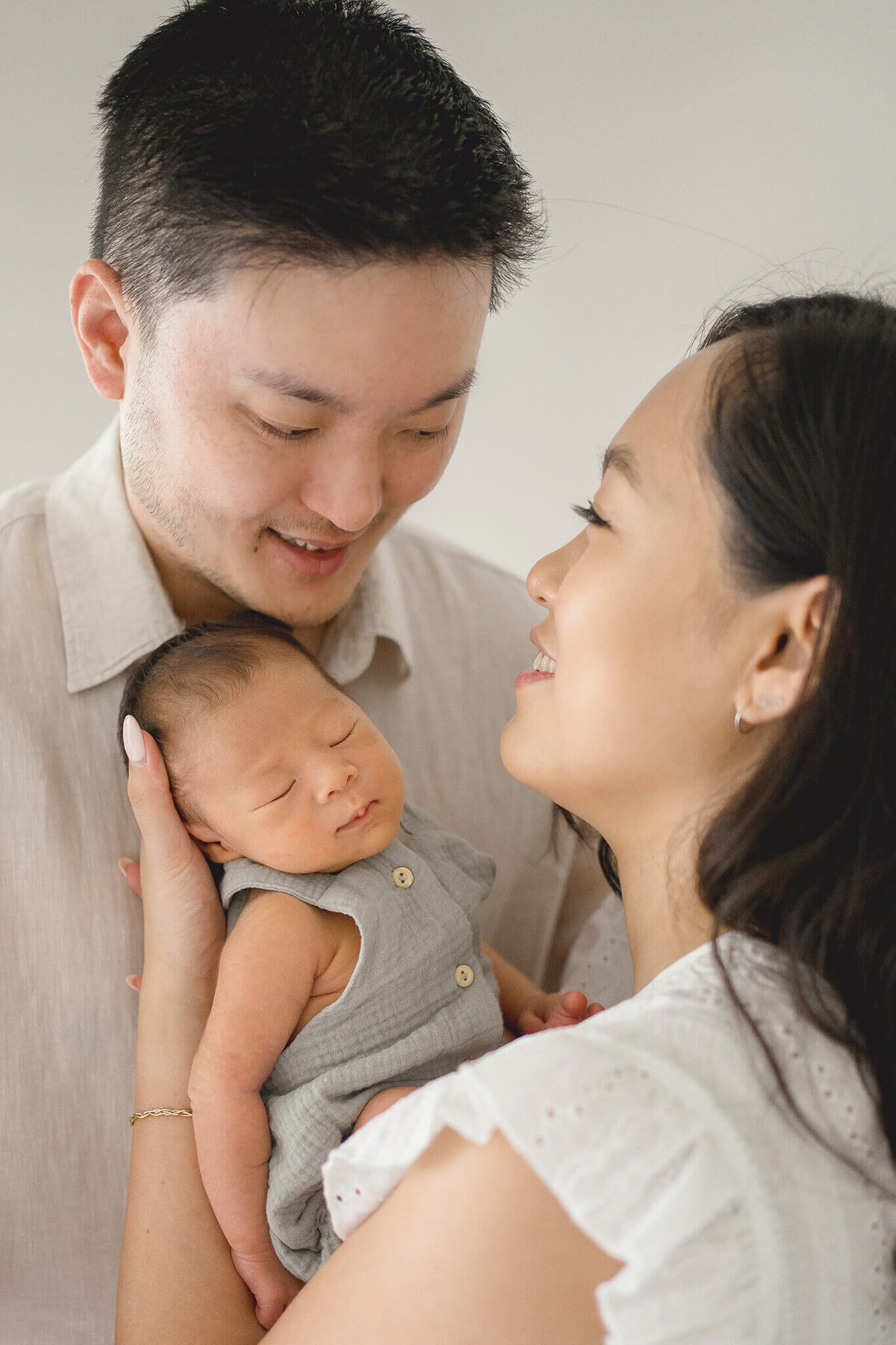 Asian couple holding newborn baby in their nursery at home with newborn maternity photographer gold coast.