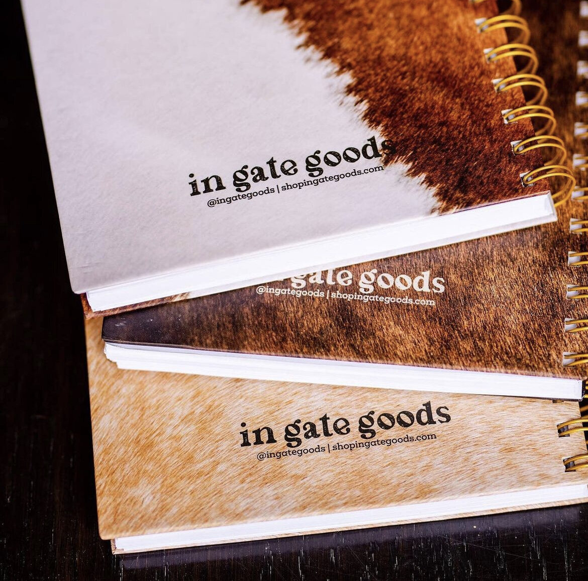 Close up photo of notebooks with image of horse hair and typographic logo printed on the back