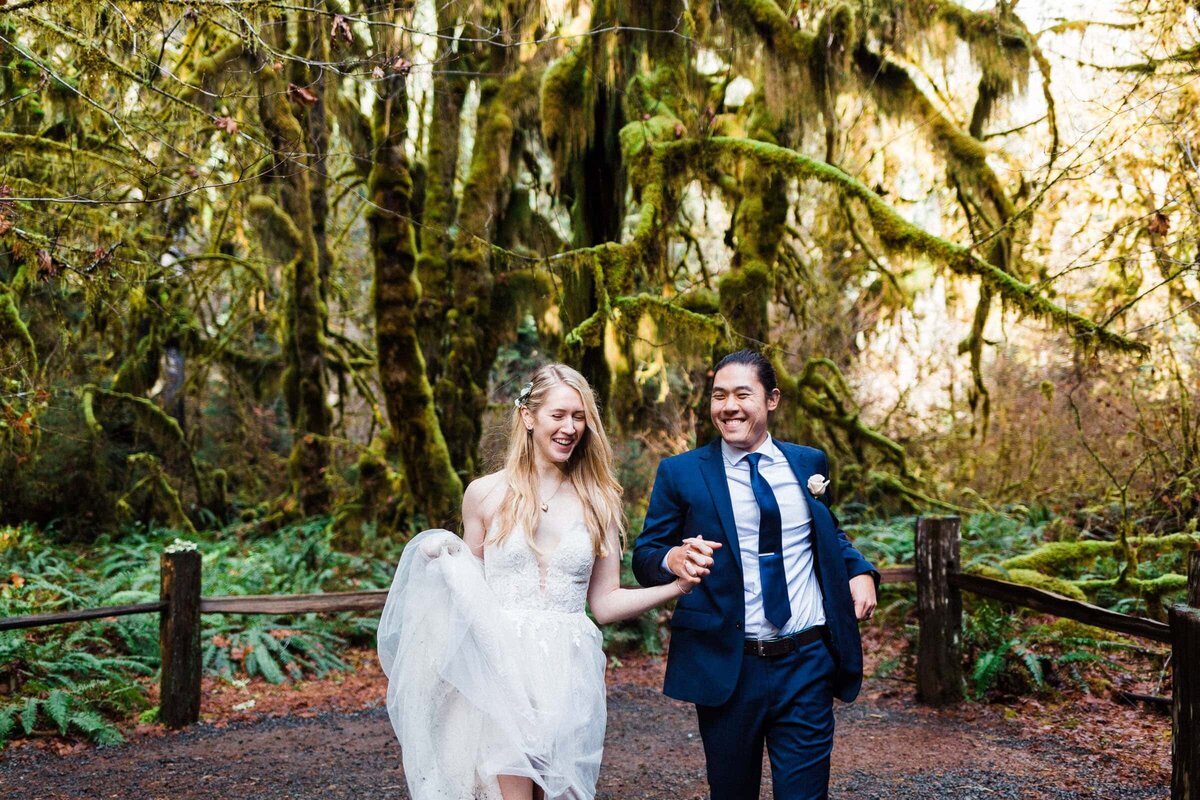 a couple running through the Hoh Rainforest in wedding attire after saying their vows.