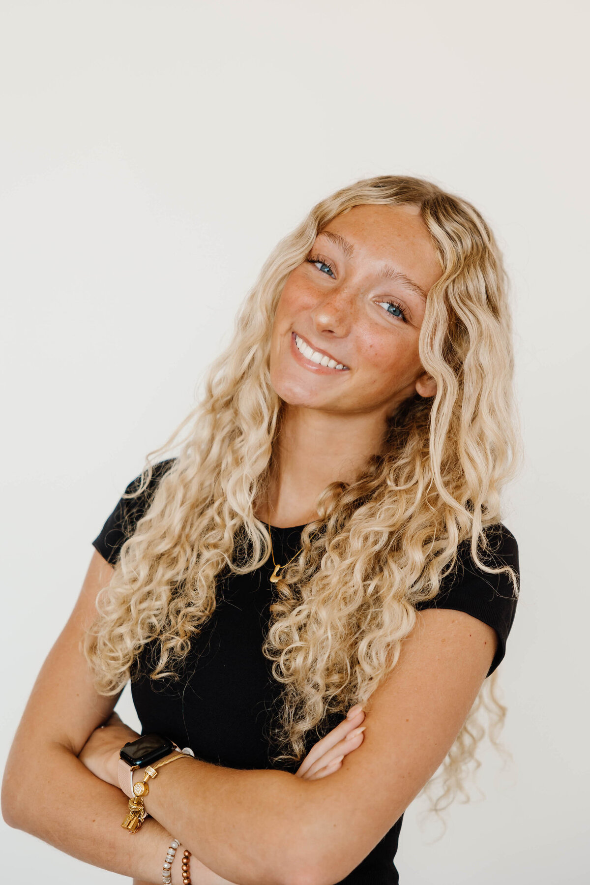 A person with their arms crossed smiling