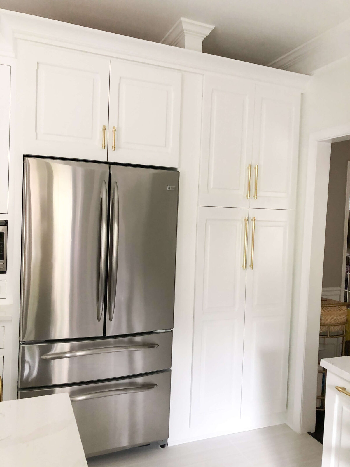 modern-white-kitchen-cabinet-gold-hardware-stainless-steel-refrigerator-