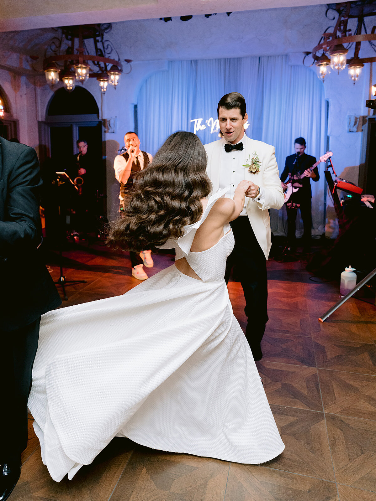 The bride and groom dance together in front of the hired band