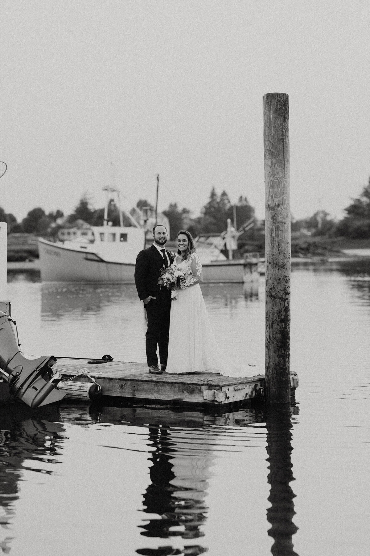 black and white image bride and groom  on dock