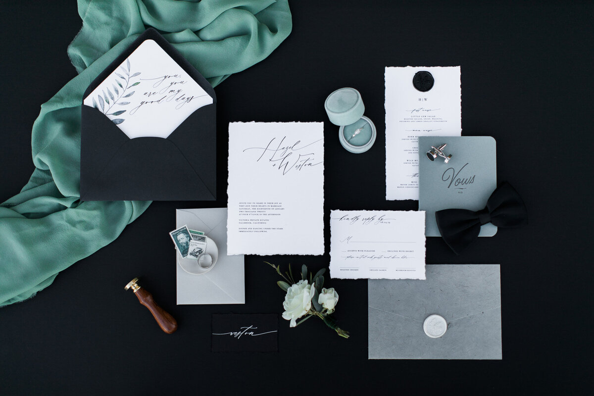 Luxury destination wedding stationery in black, white, and teal tones.