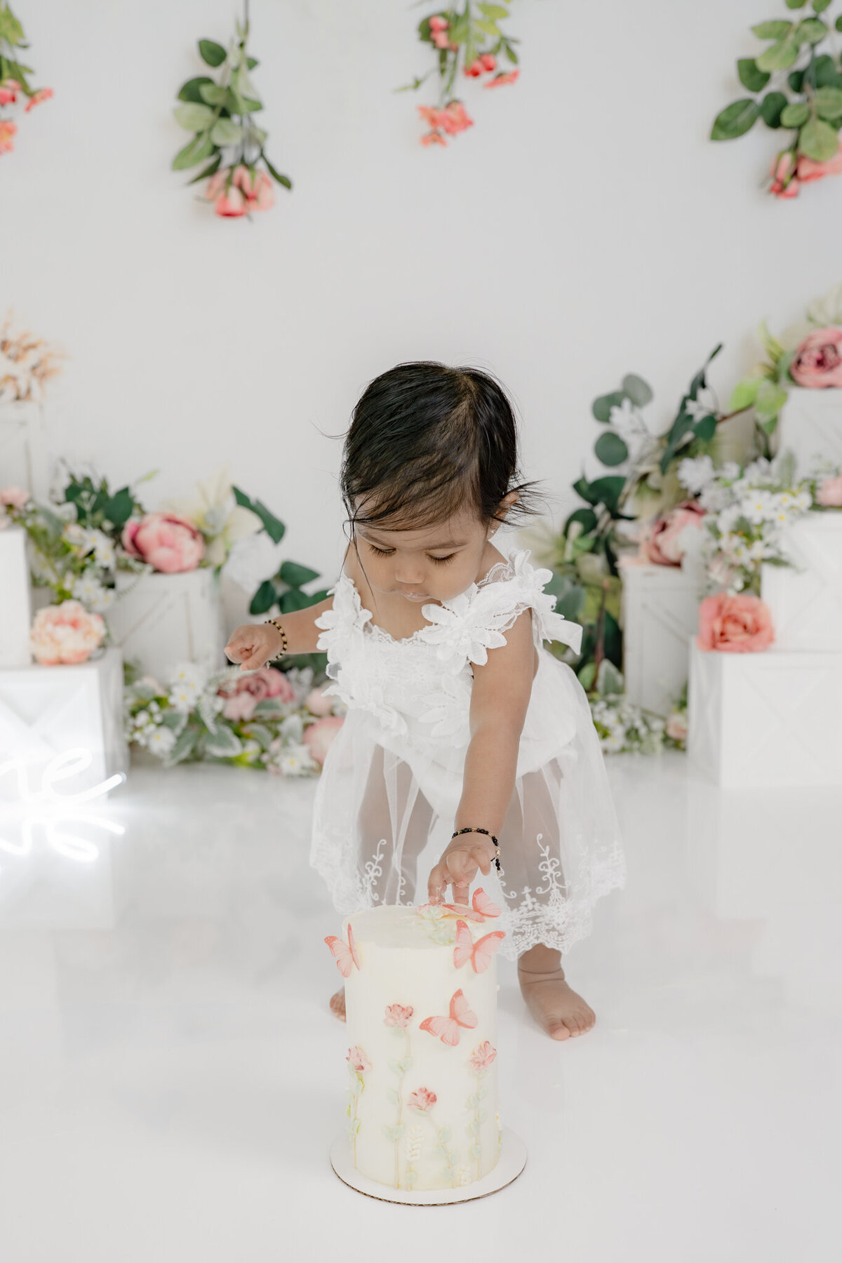 Girl eating cake during floral themed cake smash session— captured by Alliston and Barrie cake smash photographer.