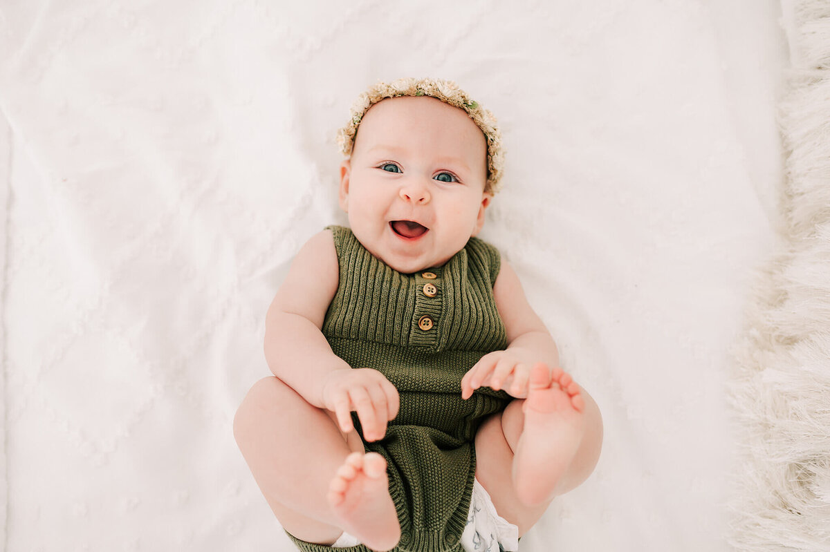 baby laying on bed during baby photographer in Springfield MO