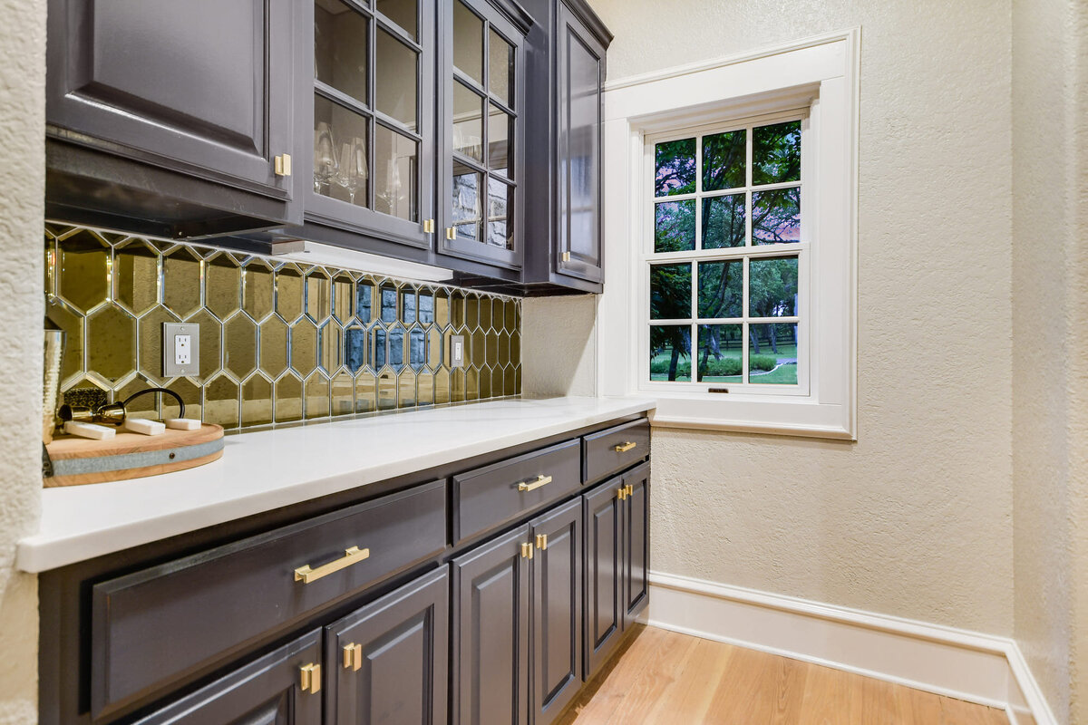 Pantry room with green tiles and dark mahogany cupboards