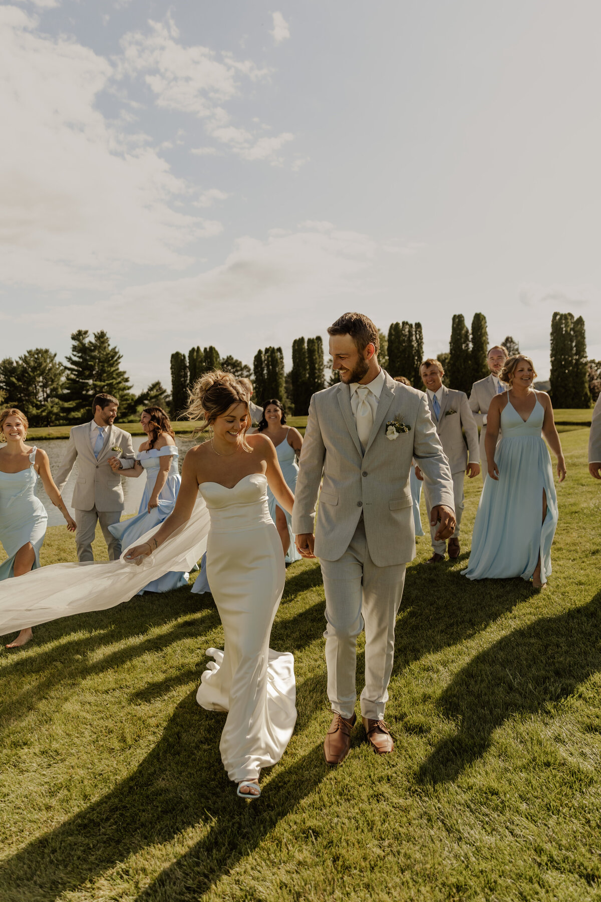 Bride and groom walking with wedding party and everyone is laughing captured by MN Wedding Photographer 