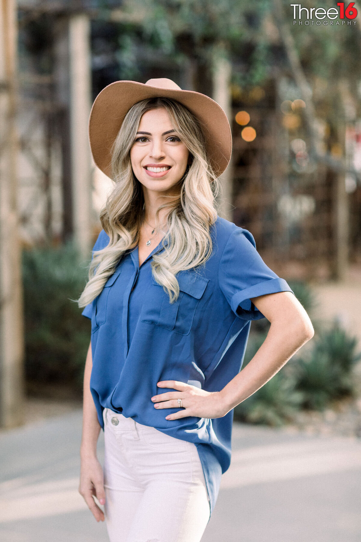 Smiling woman wearing a hat poses for headshots