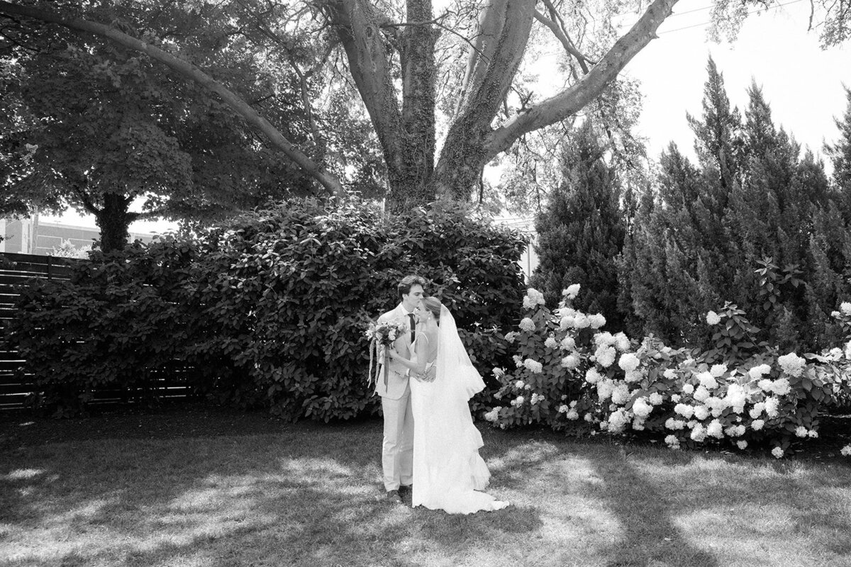 Bride and groom sharing first look outside the historic Cordell with greenery in the background.