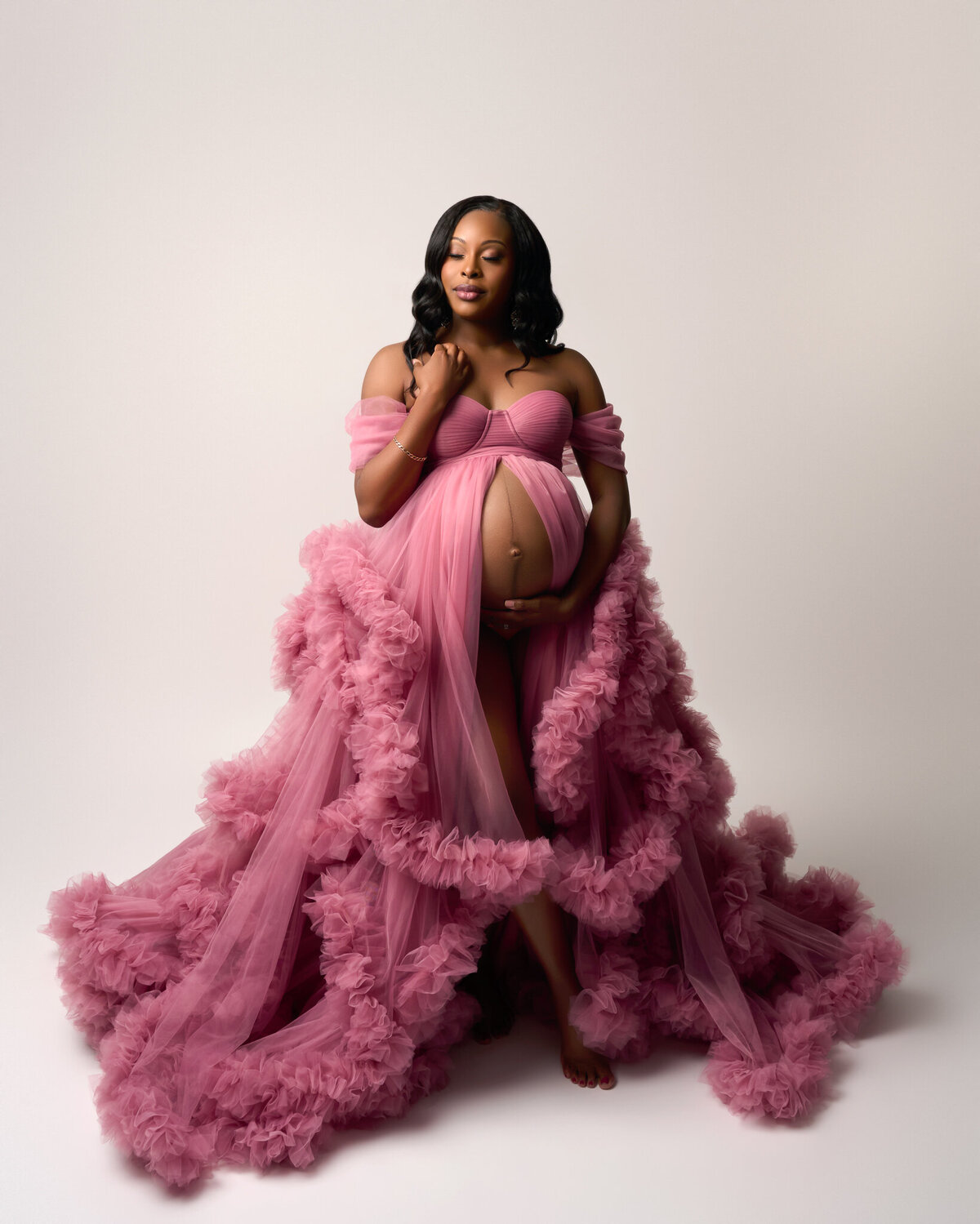 Leander maternity photographer captures elegant studio photo in dramatic pink gown