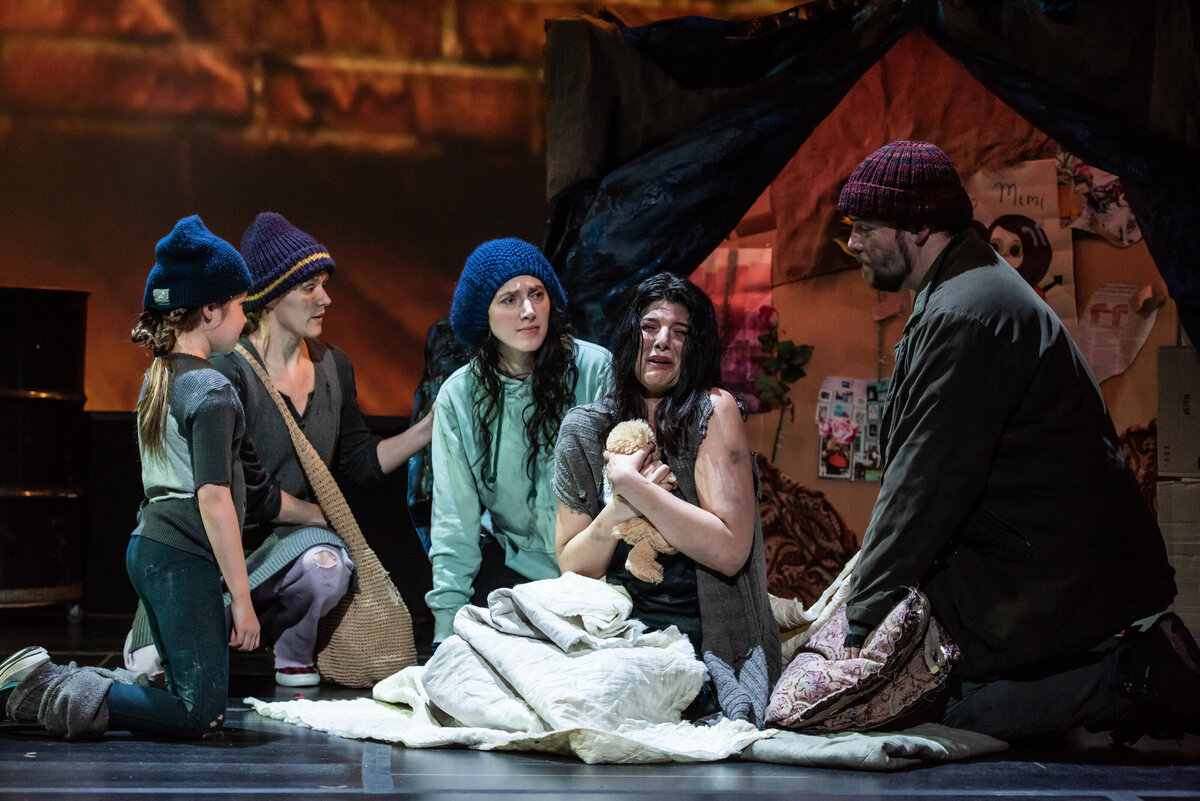 A group of people performing on stage during a play