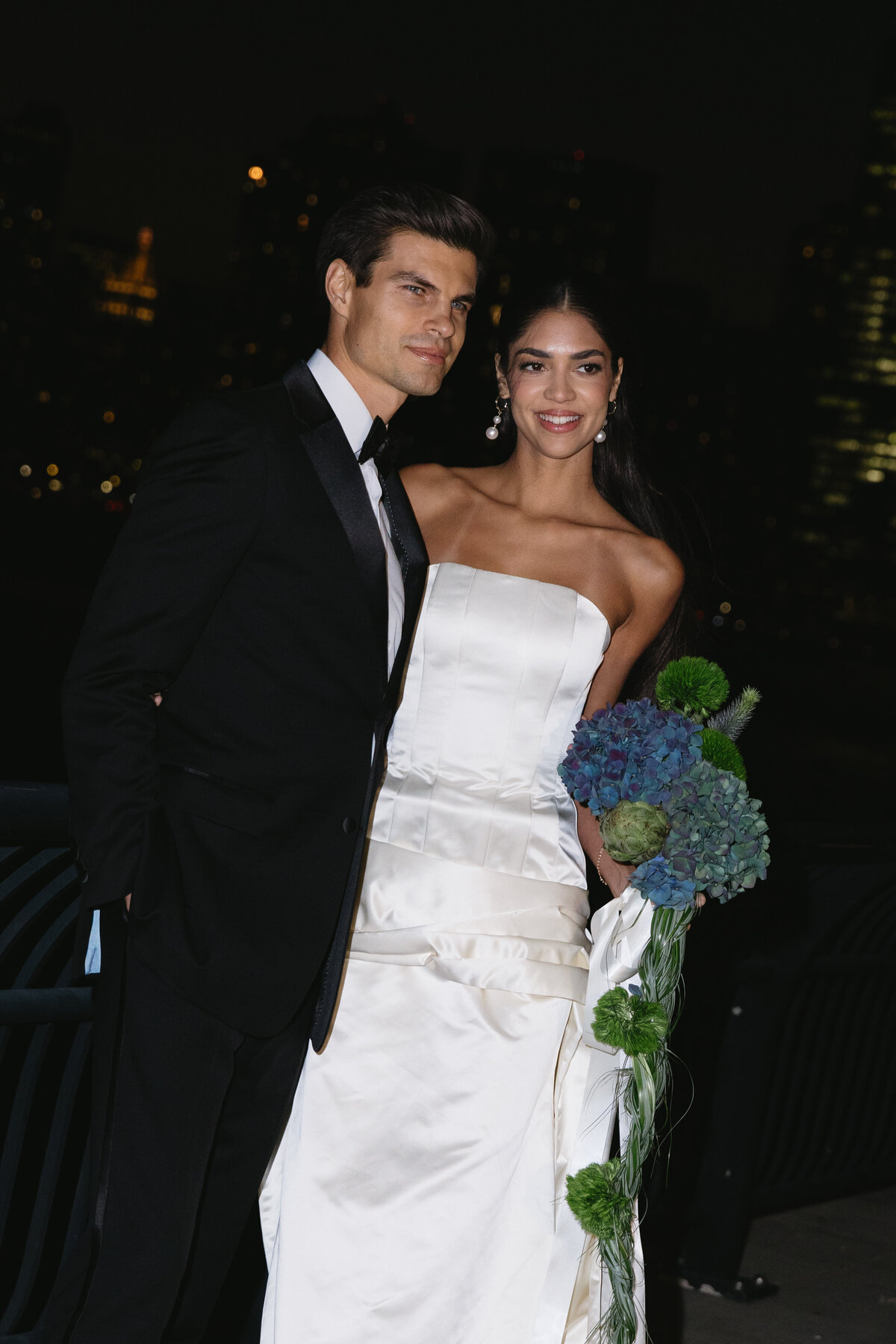 Wedding couple sharing a fashion-forward nighttime moment outdoors.