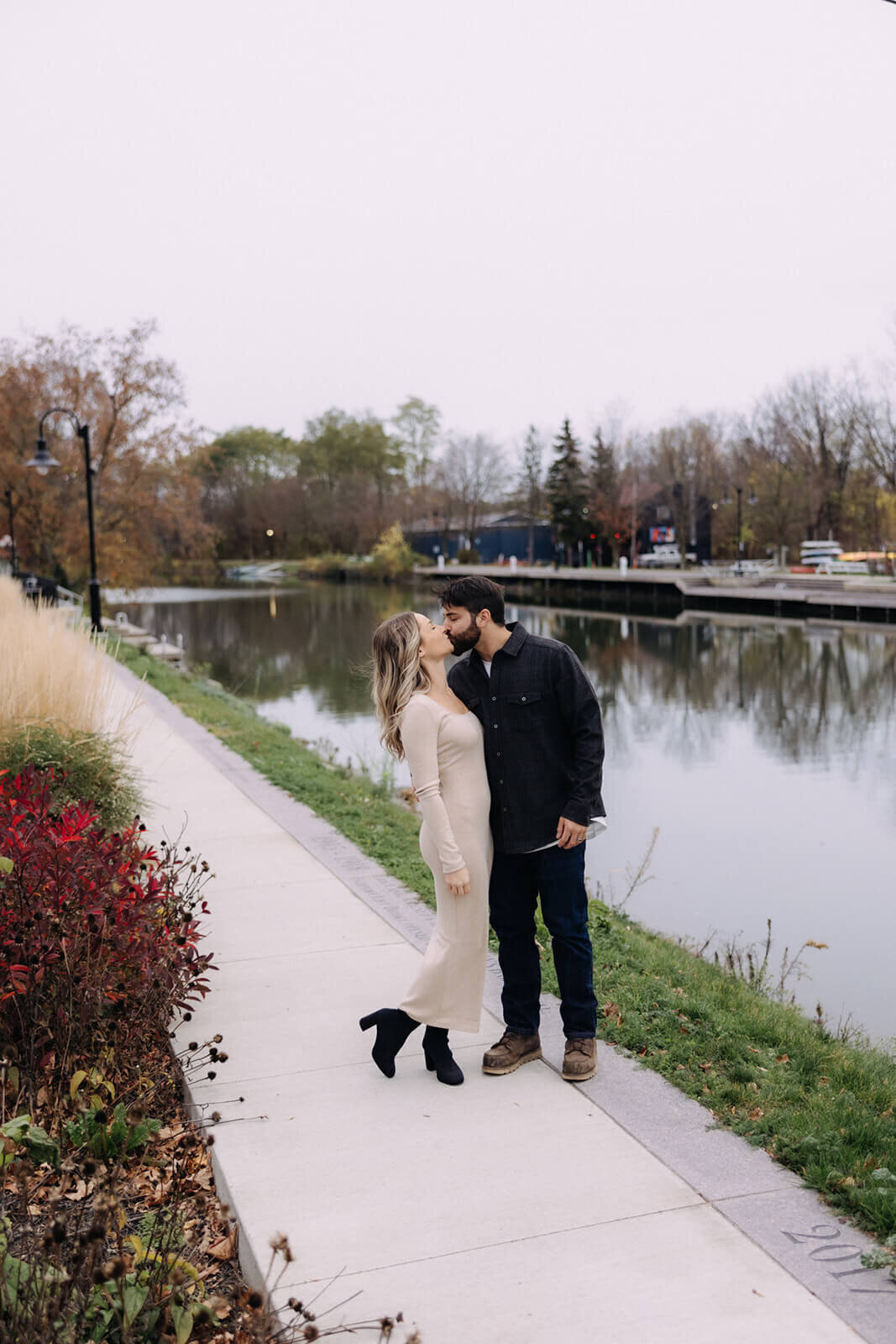 Couple kissing by lake for  maternity photos in Finger Lakes New York