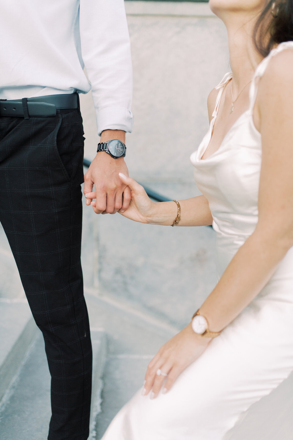Close-up of the couple’s hands intertwined, showcasing their connection and the elegance of their engagement 