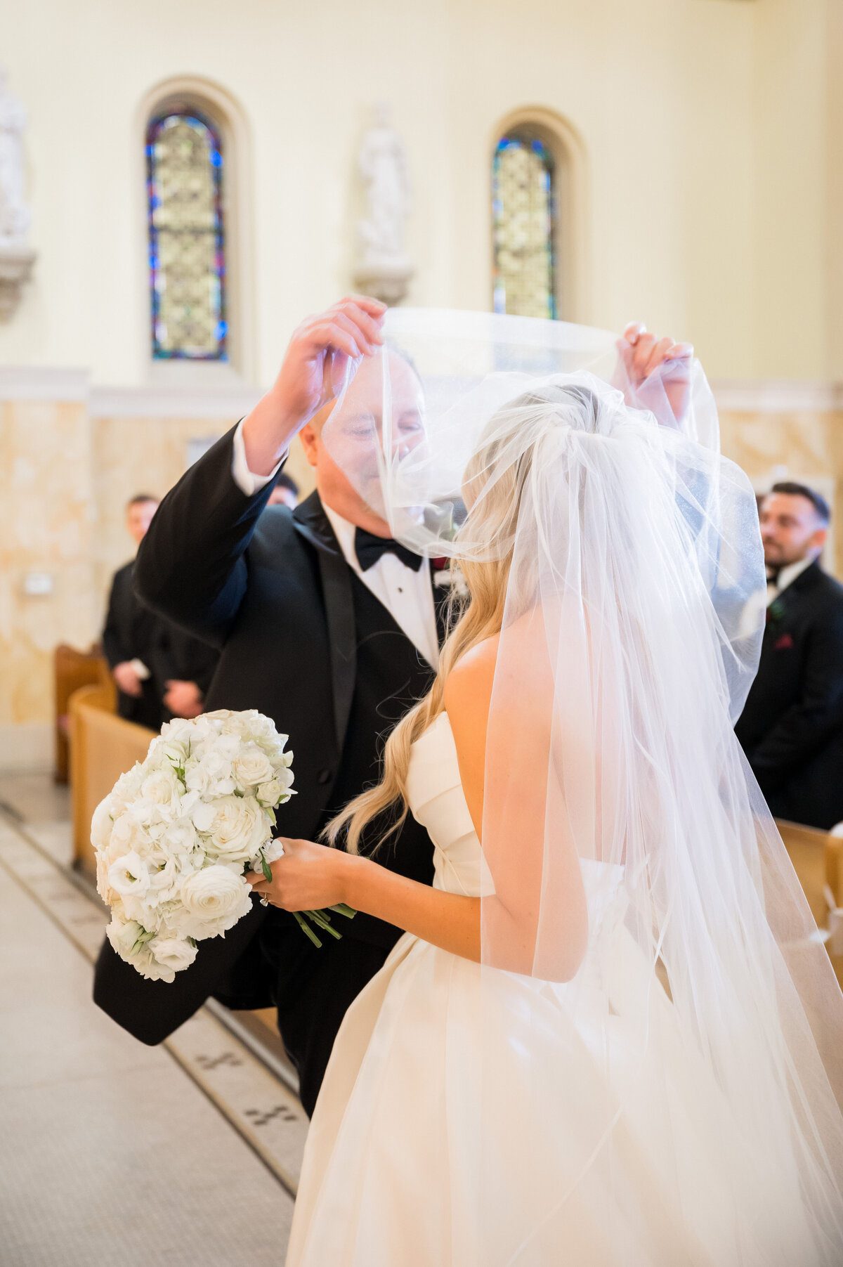 dad lifting bride's veil ar wedding ceremony in epiphany catholic church in pittsburgh