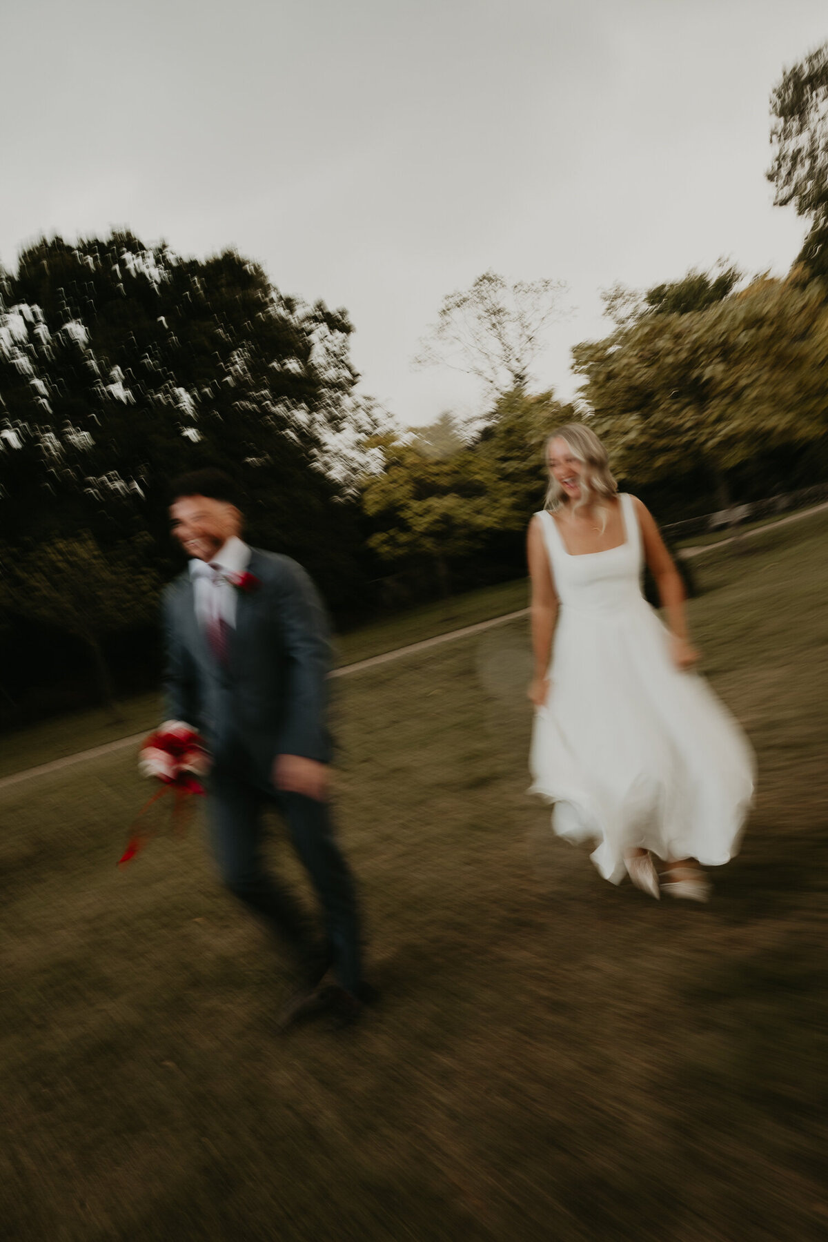 Bride and groom walk through the park in Birmingham on their wedding day. 