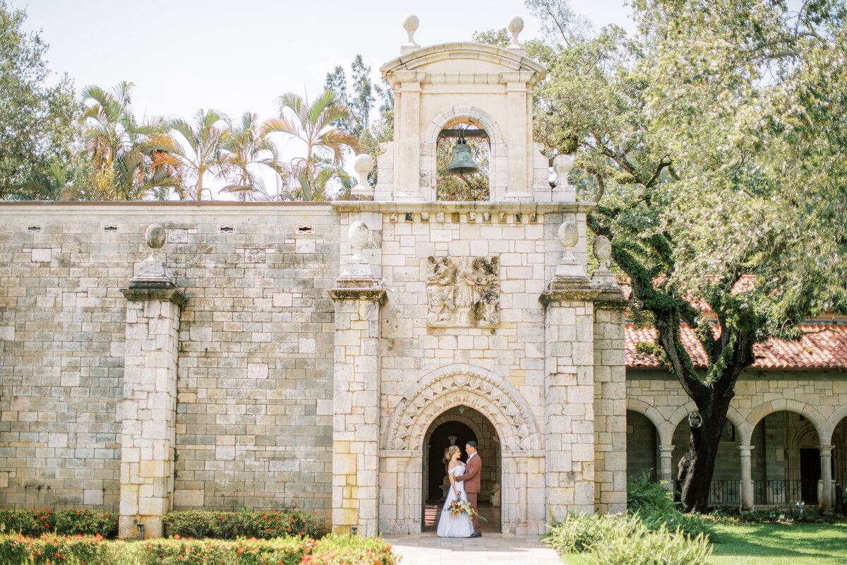 a bride and groom in an arch way at the The Ancient Spanish Monastery in miami florida