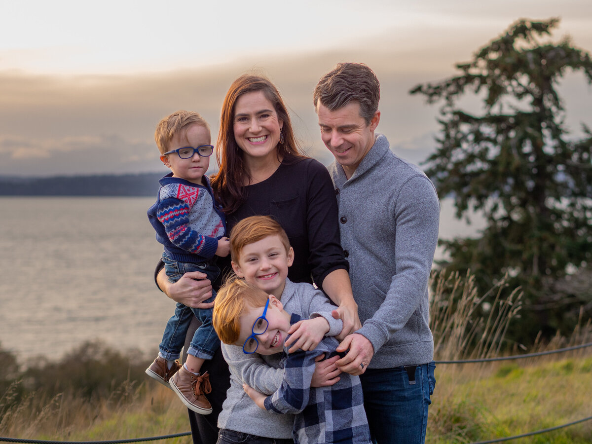 a family snuggles together and giggles during a Seattle family photo session at Richmond Beach in Shoreline, Wa.