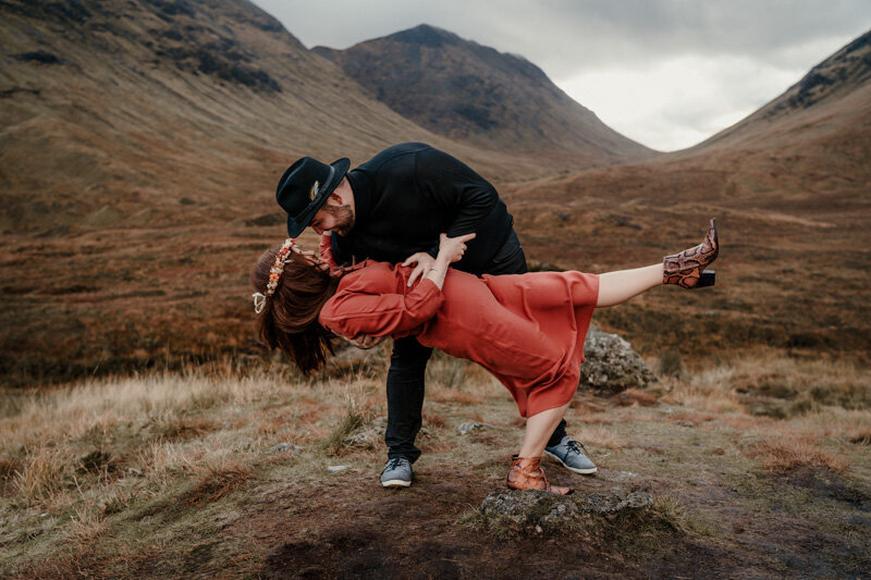 Séance couple en Écosse à Glencoe, dans un décor de montagne sauvage, capturant un moment complice et stylisé au cœur des Highlands.