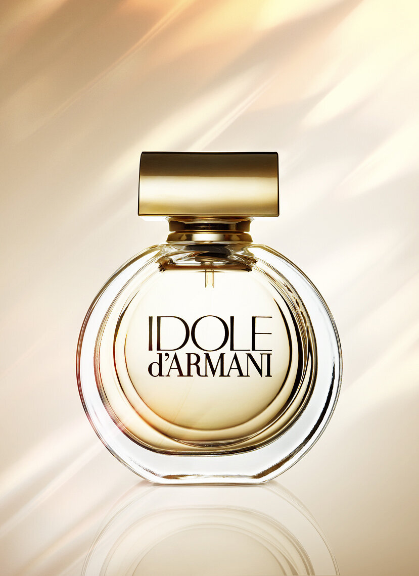 Elegant Armani perfume bottle with intricate gold details, captured by Ylva Erevall.