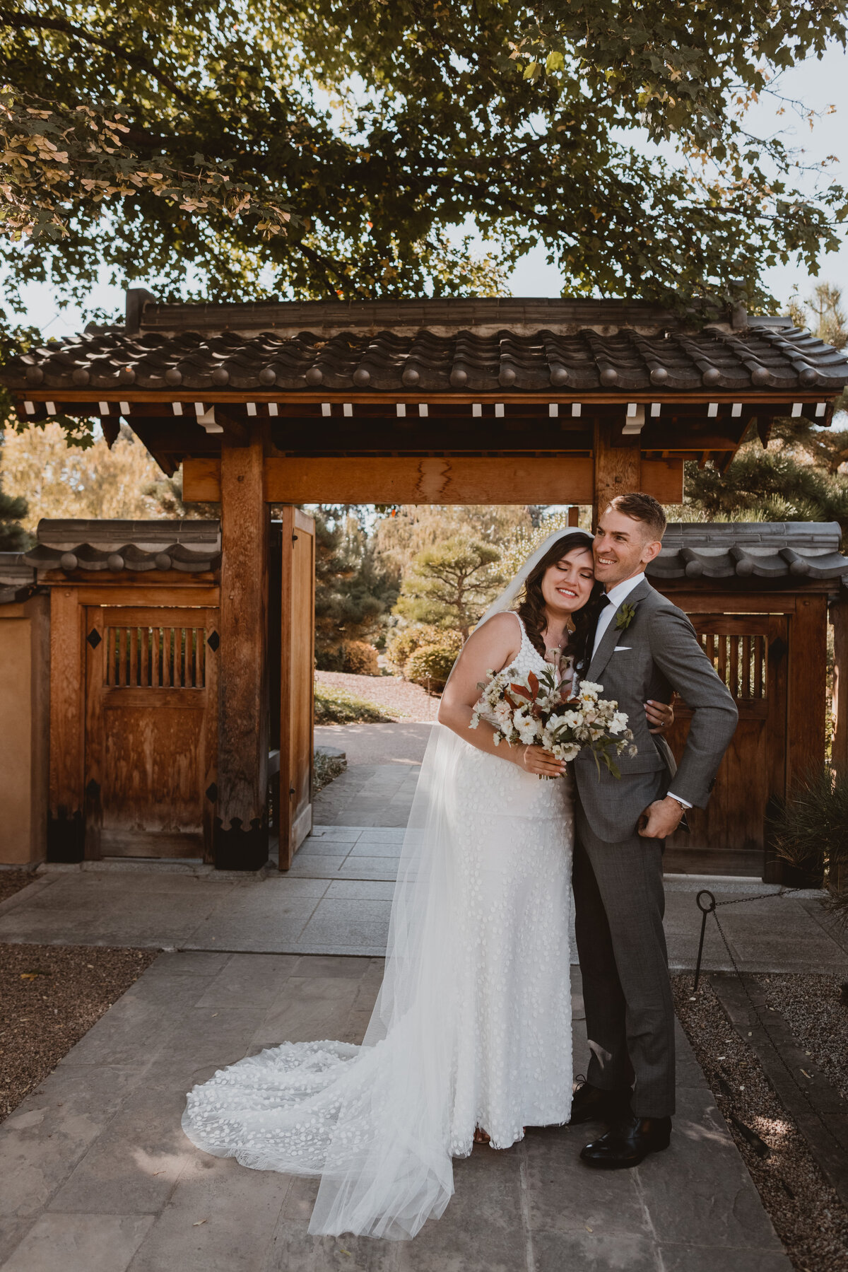 Bride and groom pose with a natural bouquet at the Denver Botanic Gardens.