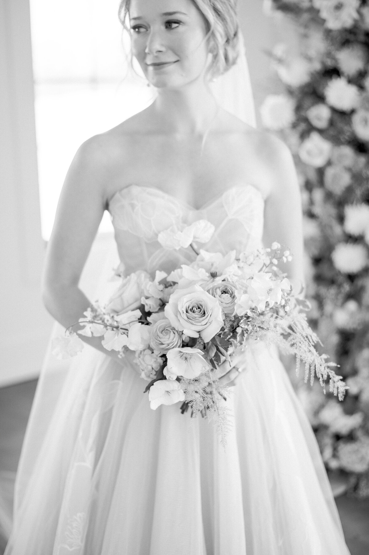 black and white bridal portrait with high-end floral arrangements