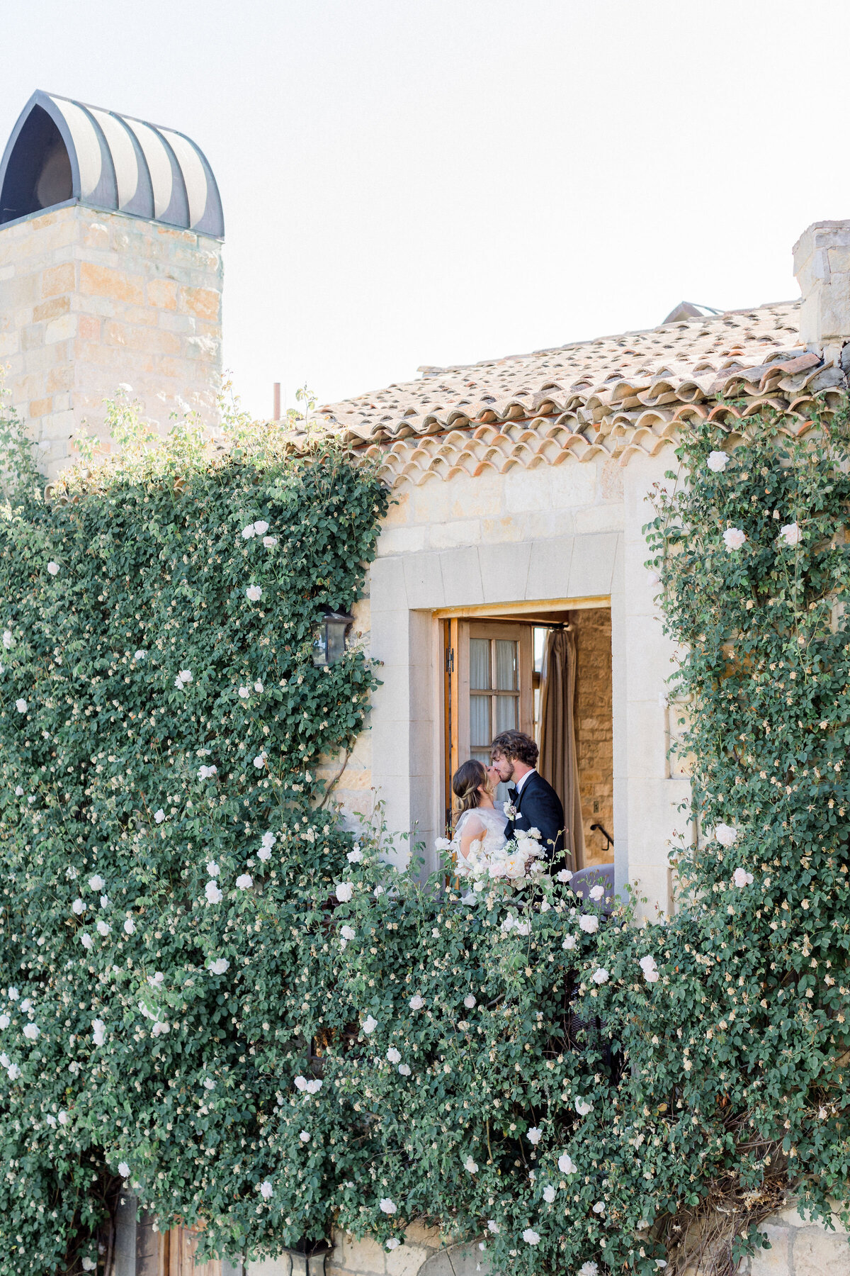 romantic-couple-kissing-balcony-floral-background-wedding-moments