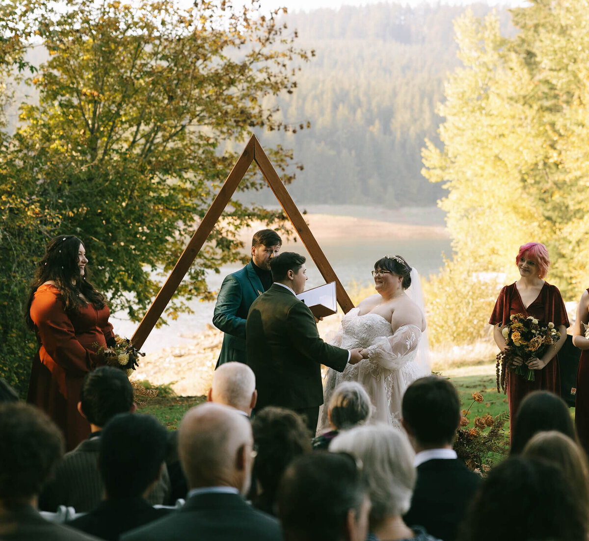 Brides hold hands during their outdoor wedding ceremony at Sky Camp Oregon.