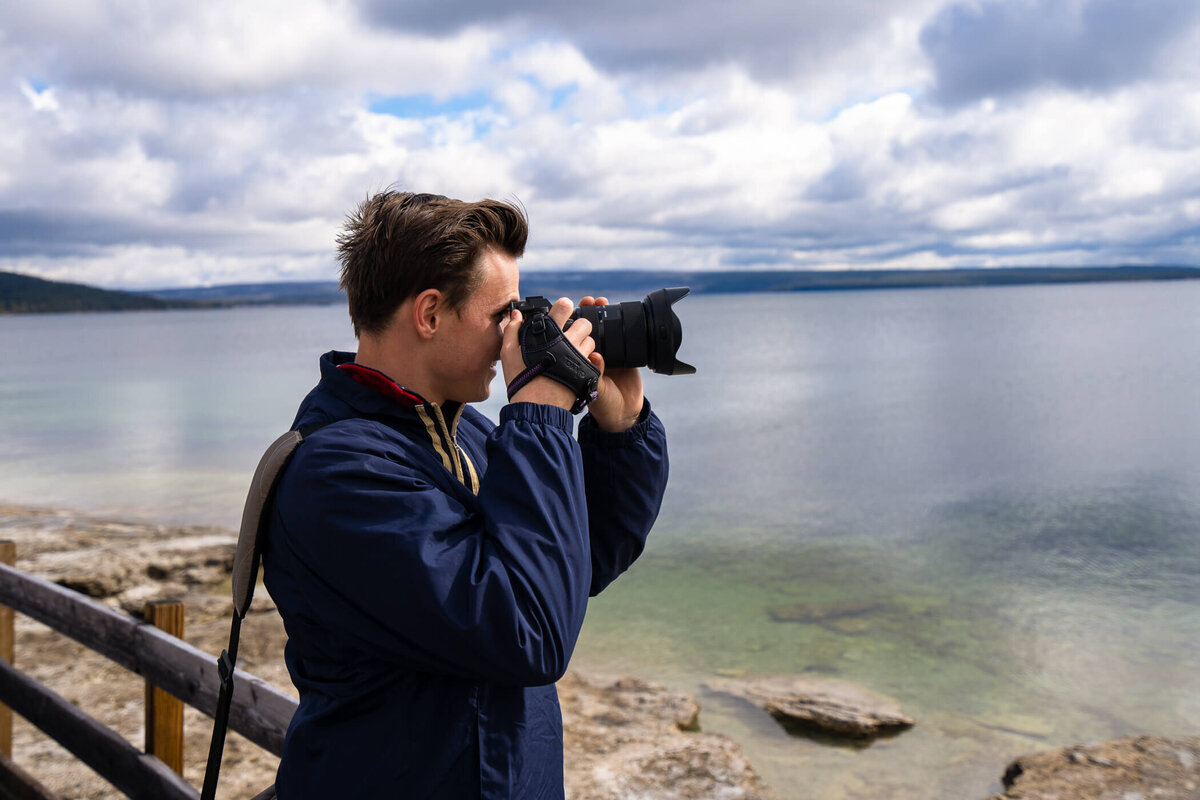 Candid portrait of Michael Fricke with his eye up to the camera, capturing landscapes in Yellowstone National Park, Wyoming