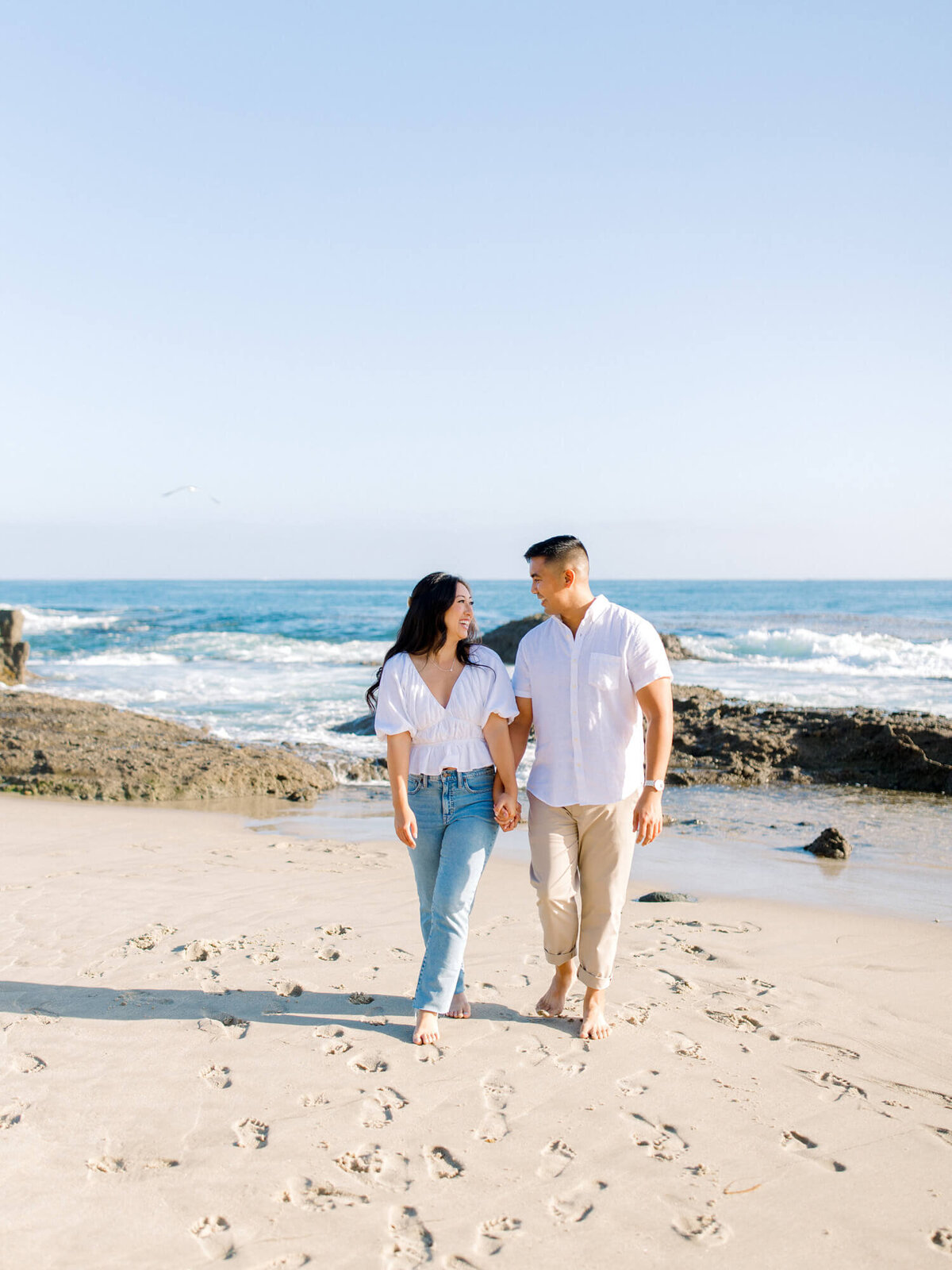 documentary engagement photo of couple walking on beach