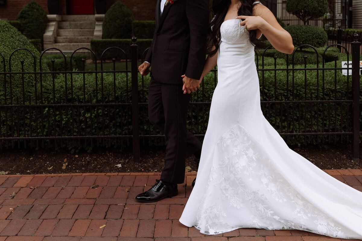 wedding couple holding hands walking down sidewalk at destination wedding