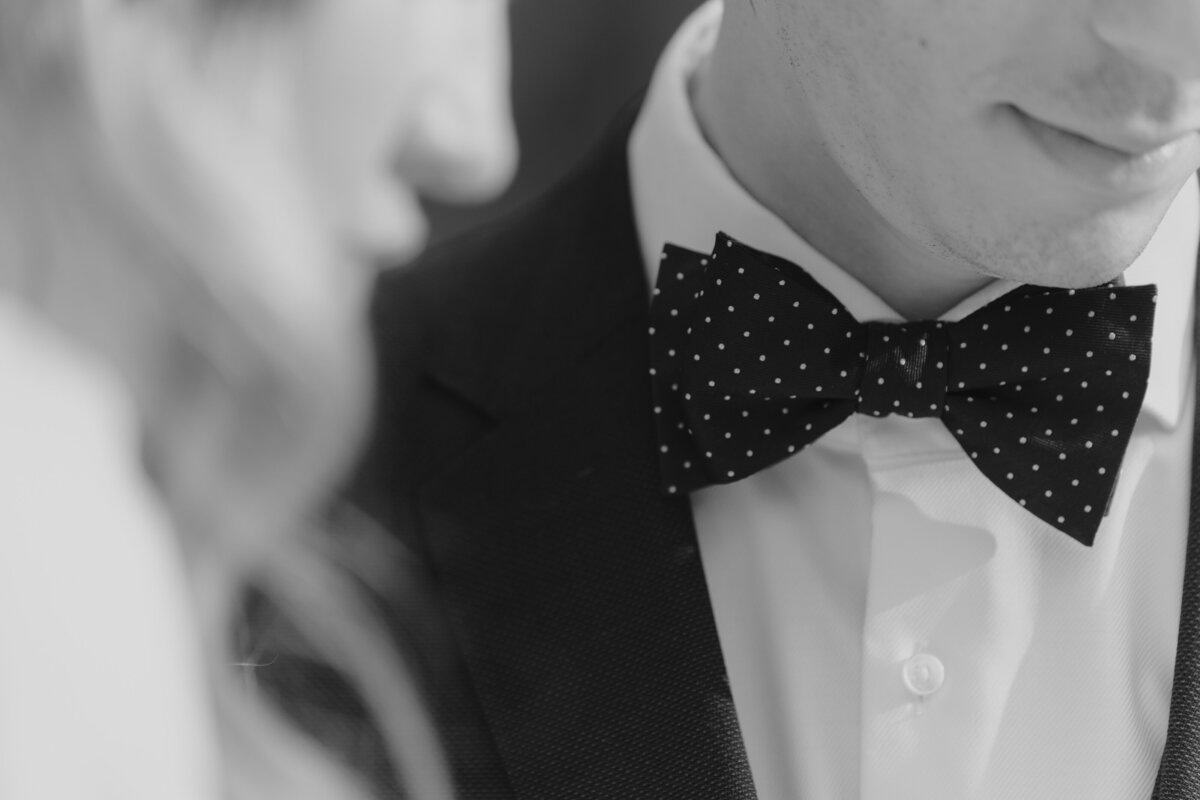 the groom's polka dots bow tie and his black suit
