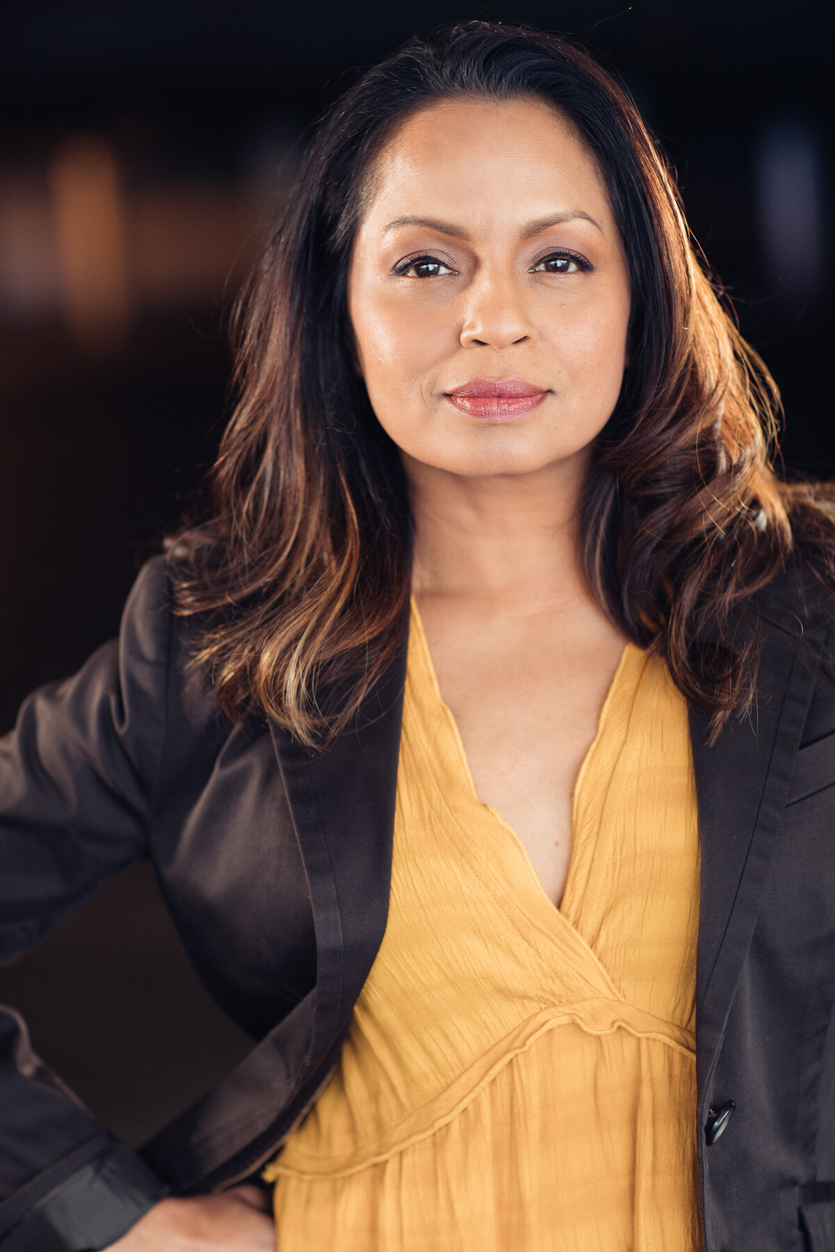 Headshot Photograph Of Woman In Outer Brown Jacket And Inner Yellow Blouse Los Angeles