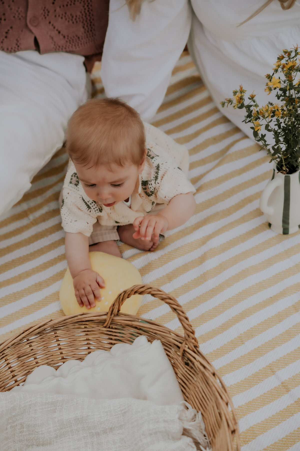 Zoontje speelt op picknick deken tijdens familie fotoshoot op de Kalmthoutse Heide
