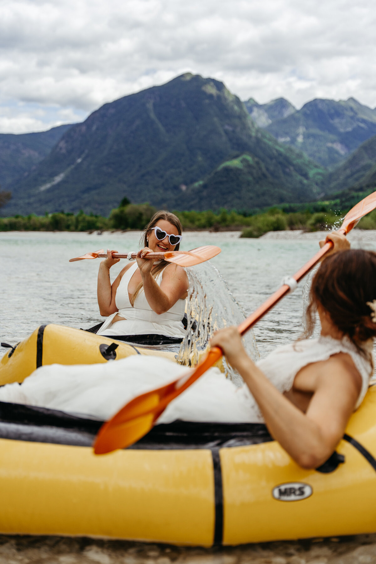 romantic couple in wedding dresses kayaking Soča River
