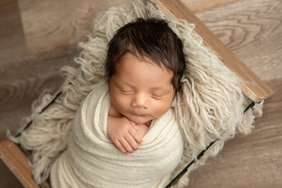 Edmonton newborn studio bucket pose with bone flokati
