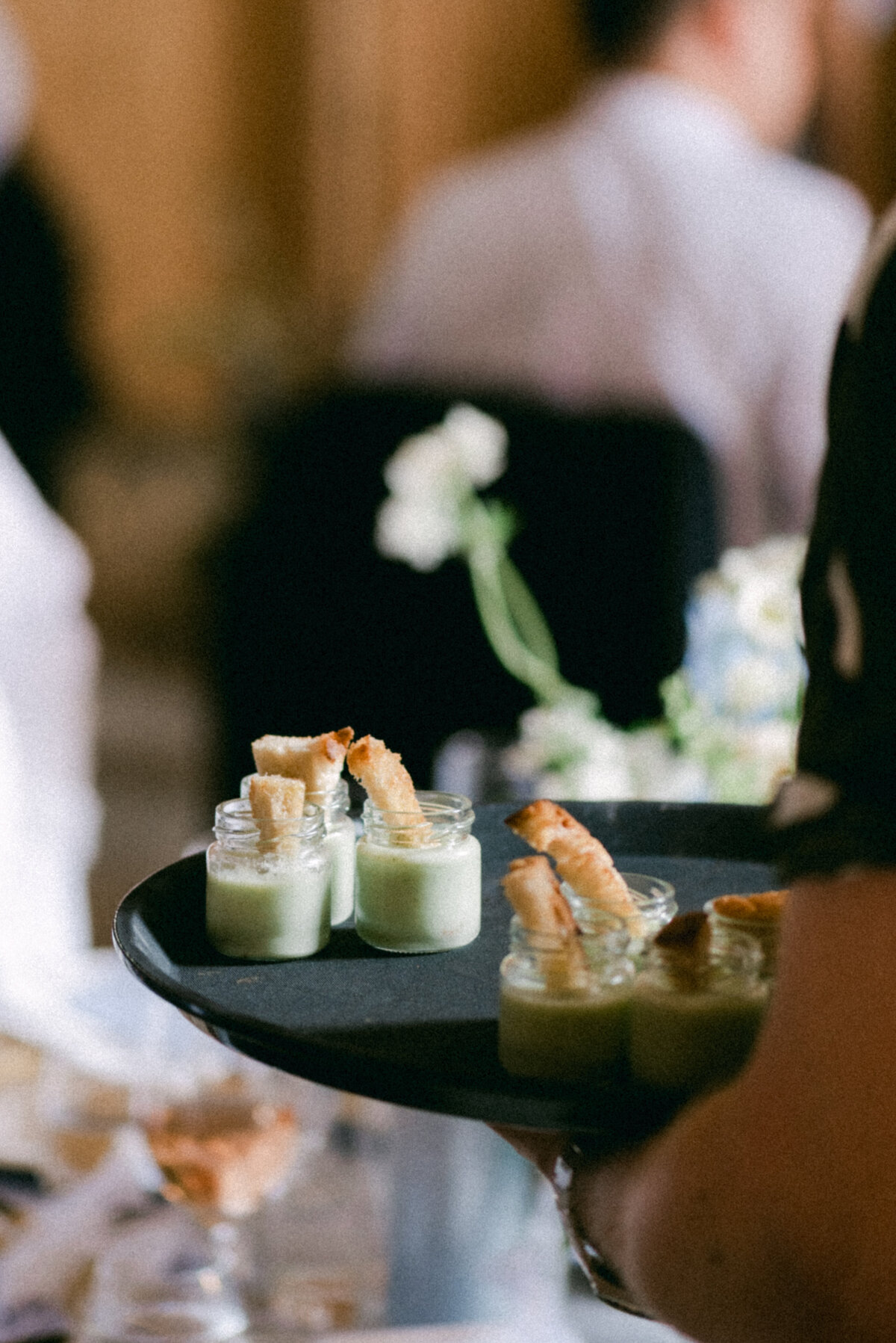 A waiter serving wedding dinner in an image photographed by wedding photographer Hannika Gabrielsson.