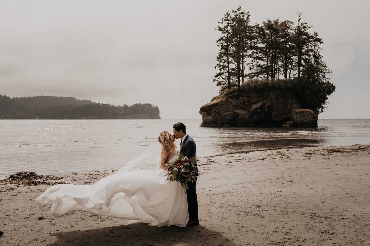 Bride & groom kissing as the bride's dress blows in the wind at Salt Creek Recreation Area!