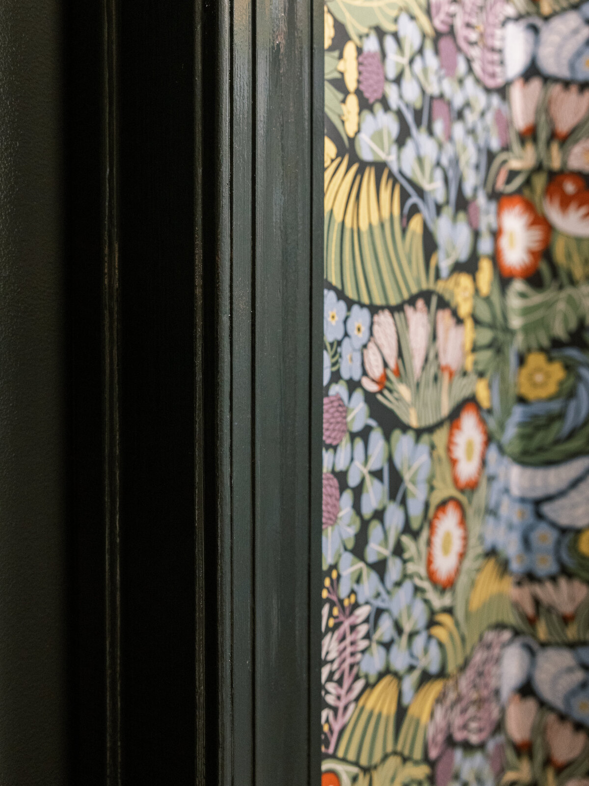 Black door casings  accenting the black floral wallpaper