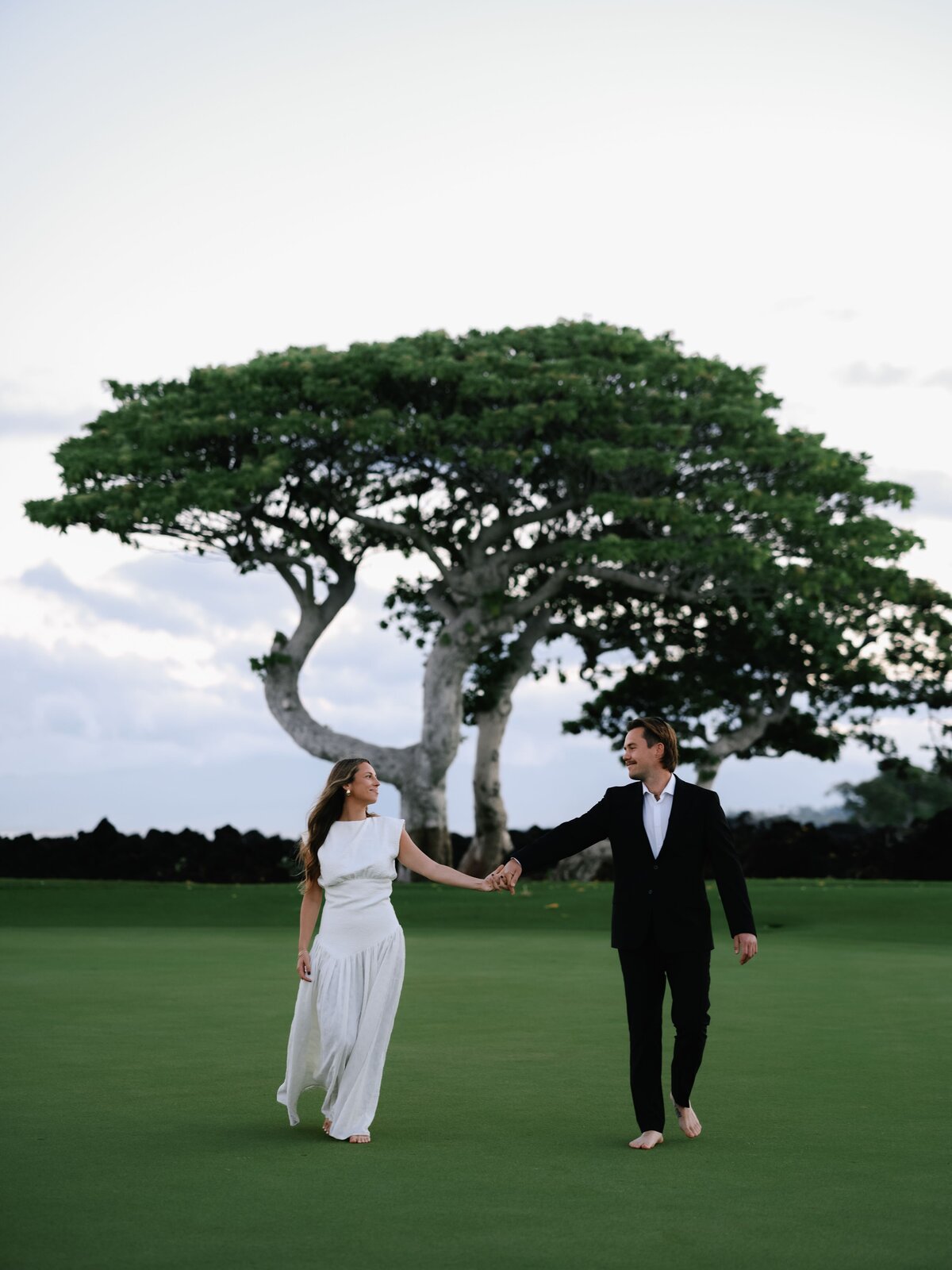 bride and groom walking together in hualalai