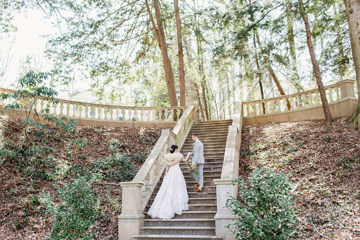 Bride and groom walking up stairs.