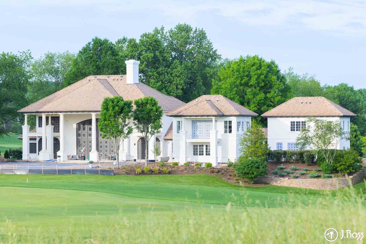 Completed view of the sprawling stucco estate, now fully painted in bright white with dark accents, demonstrating the successful scale and quality of home exterior painting Bristol, VA.