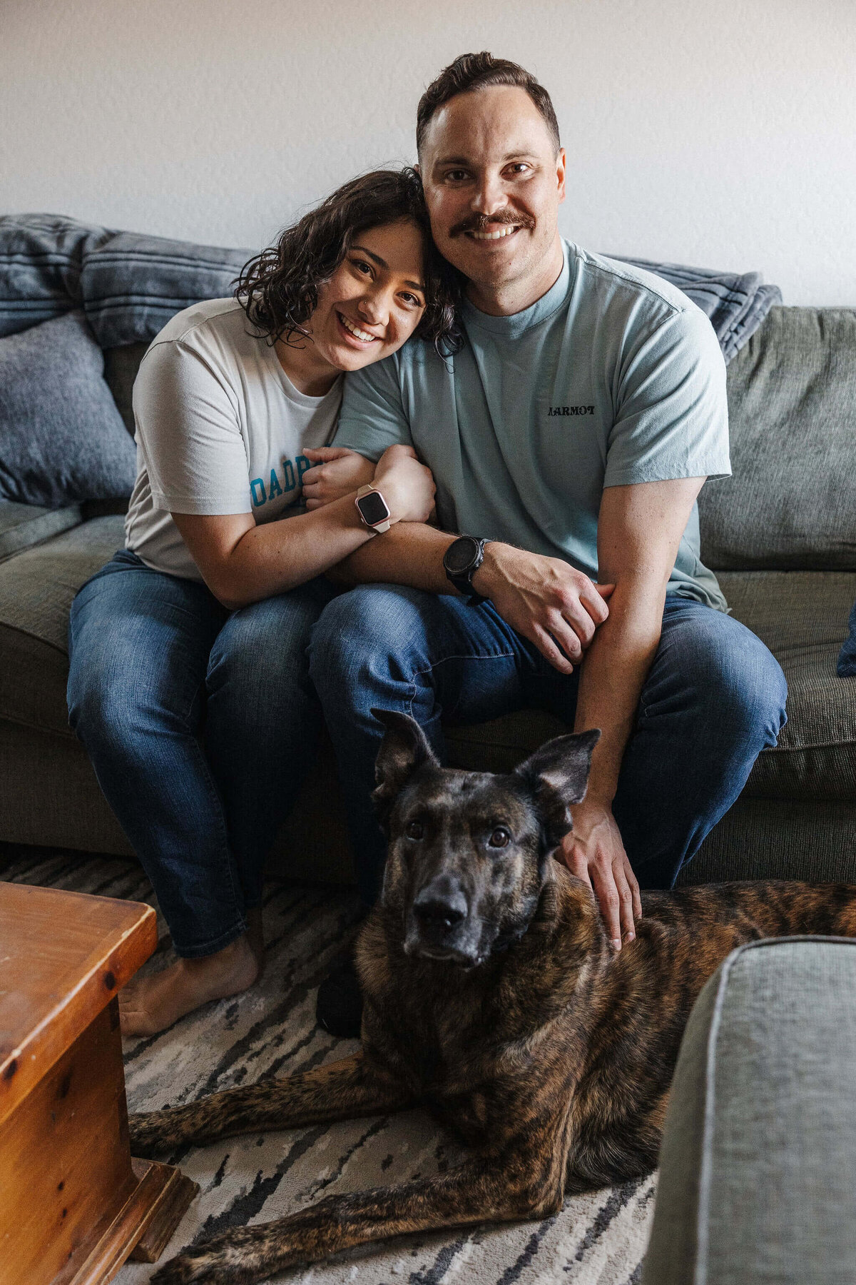 Couple, Cactus & Pine Photography owner and husband sitting together smiling on couch with dog Captured by Rachel Richards Photo and Film
