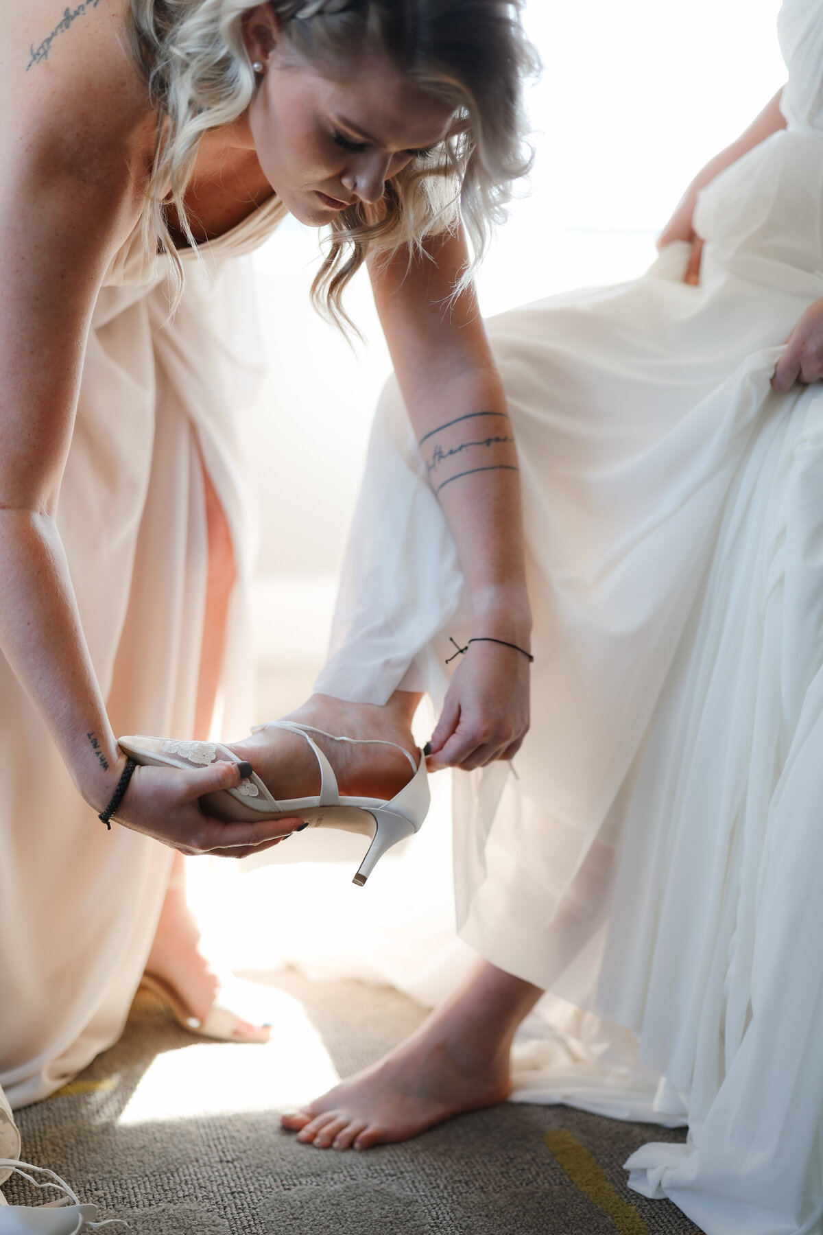 Bride preparing for her wedding day, gently adjusting her veil and dress in a peaceful, light-filled room.