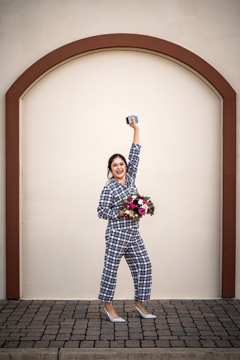 The bride makes a fun and unforgettable entrance at Casa Real in her cozy pajamas, striking a playful pose before changing into her wedding dress, perfectly capturing her vibrant personality and excitement for the big day.